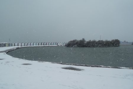 Lake With Island And Surrounding Beach Huts In Snow