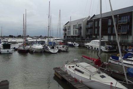 Marina With Boats And Yachts With Modern Flats In Background