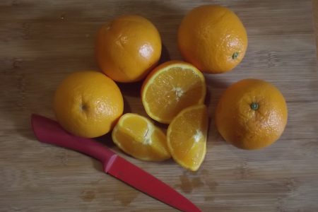 Oranges On A Chopping Board With A Knife