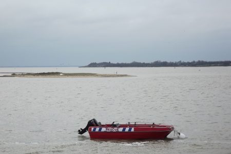 Rescue Boat On Sea With Island Behind